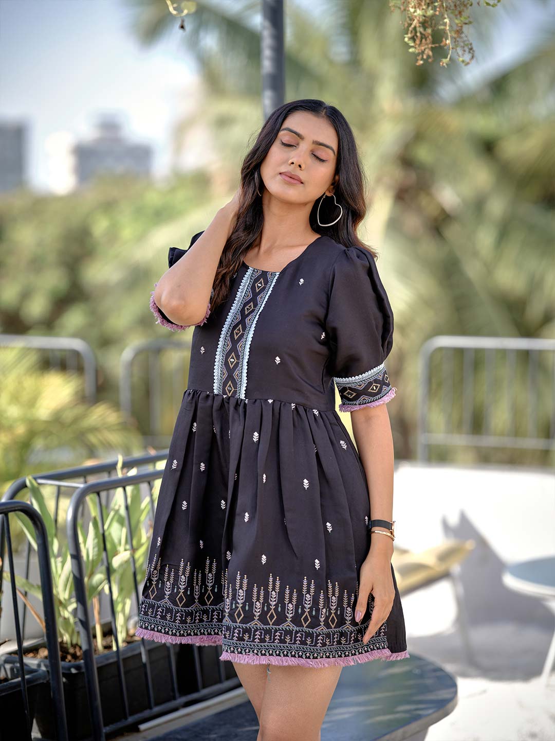 A woman wearing a black heavy rayon tunic with round neckline and half sleeves